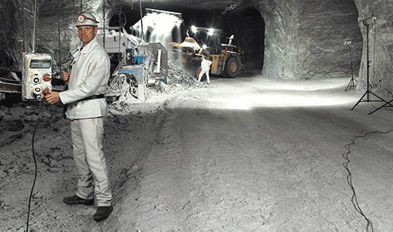 a man in a white suit stands in a salt mine holding an AMAXX receptacle combination